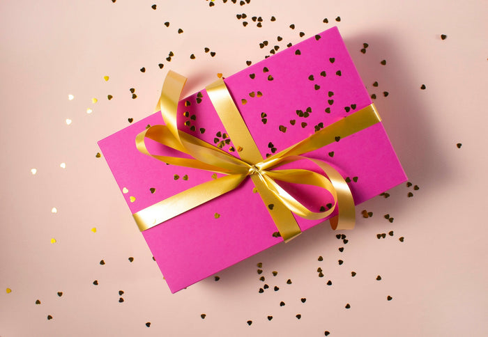 Boîte cadeau rose avec ruban doré